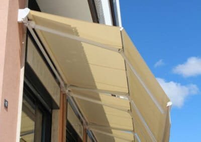 Tenda a bracci inclinate a pantografo per balconi